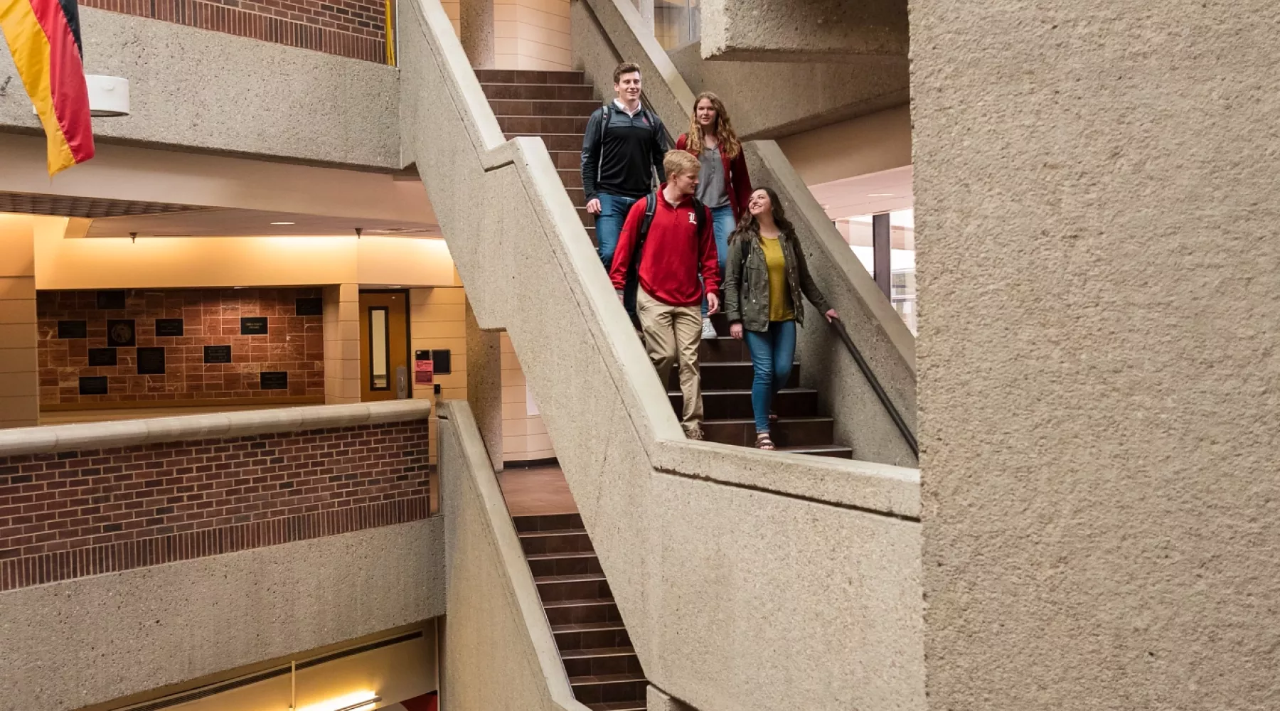 Students walk down the steps of the College of Business