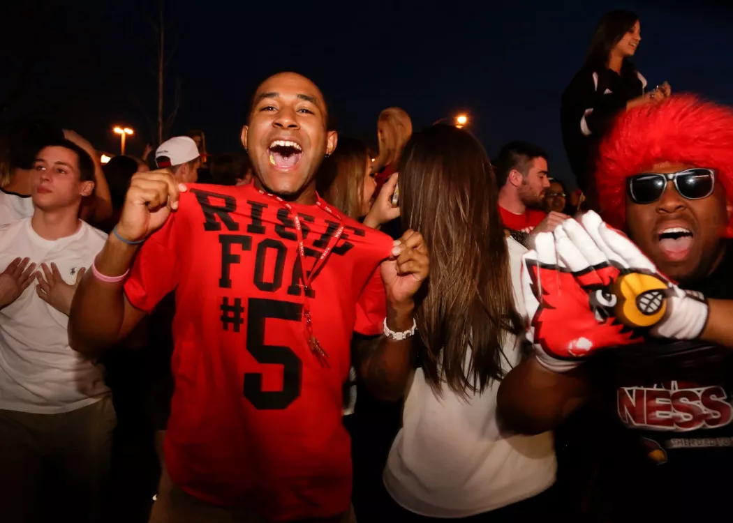 In the background UofL fans celebrate a game