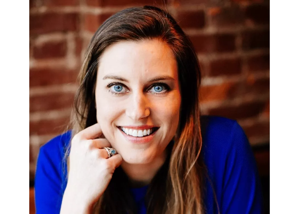 A woman resting her head against her knuckle.