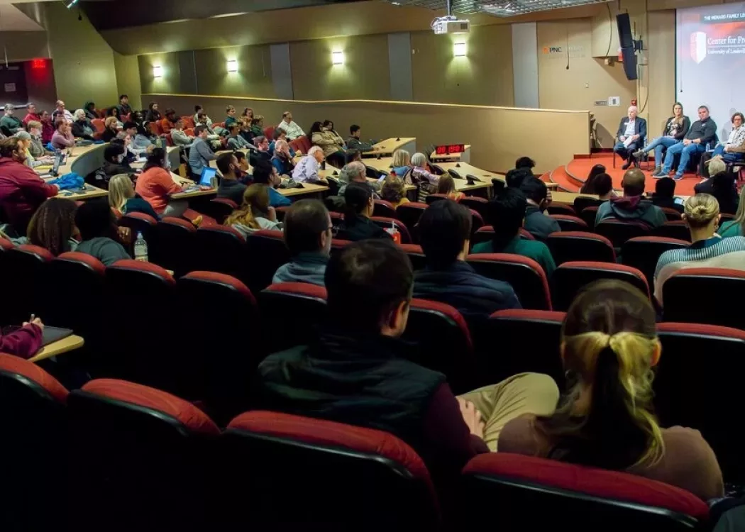 Group of people sitting in the Horn Auditorium watching a panelist event.
