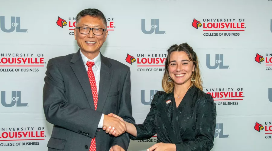 UofL College of Business Fall22 PMBA student, Sonja Faul,  accepts diploma from Interim Dean, Jeff Guan, at the Professional MBA graduation dinner in the PNC Club.