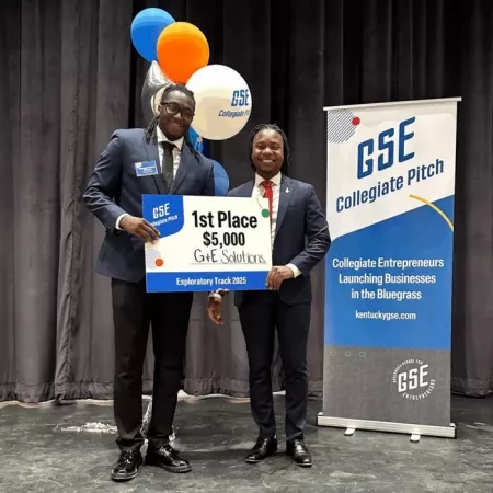 Golden Mashindi posing with G&E Rep with big check on stage.