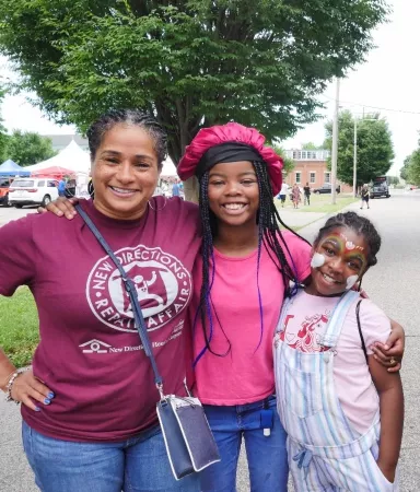 Woman and two young girls casually dressed posing for photo